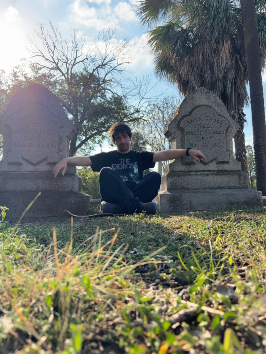 Nicolás sentado entre dos lápidas del siglo XIX en el cementerio Oakwood de Austin